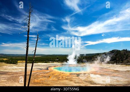 Besucher sehen die Grand Prismatic Spring, während der Dampf im Yellowstone-Nationalpark steigt. Die farbenfrohe heiße Quelle zieht jedes Jahr viele Touristen an. Stockfoto