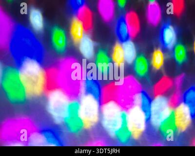 Farbenfrohe, unscharfe LED-Leuchten schaffen einen abstrakten Bokeh-Hintergrund. Festlich leuchtende Beleuchtung in Blau-, Gelb- und Rosa-Tönen, Weihnachtsdekoration konc Stockfoto