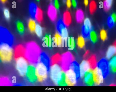 Farbenfrohe, unscharfe LED-Leuchten schaffen einen abstrakten Bokeh-Hintergrund. Festlich leuchtende Beleuchtung in Blau-, Gelb- und Rosa-Tönen, Weihnachtsdekoration konc Stockfoto