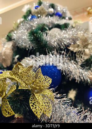 Geschmückter Weihnachtsbaum mit blauen und silbernen Kugeln, glänzendem Lametta, festlichen Ornamenten und grünen Kiefernzweigen. Klassischer Winterurlaub Hintergrund mit Stockfoto