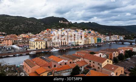 Atemberaubendes Panorama von Bosa, einer historischen sardischen Stadt, die für ihre farbenfrohe Architektur berühmt ist. Die Aufnahme hebt die regenbogenfarbenen Häuser hervor Stockfoto