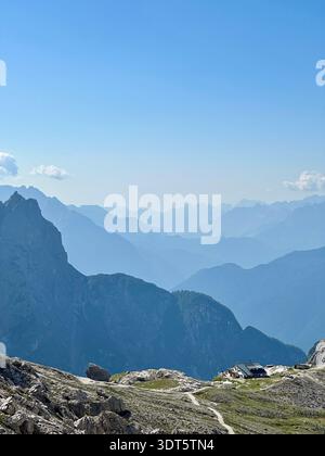 Blaue Bergschichten verblassen von einem felsigen Aussichtspunkt in die Ferne unter einem klaren Sommerhimmel Stockfoto