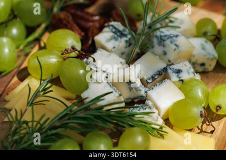 Rustikale Vorspeiseplatte mit Käse und Trauben. Stockfoto