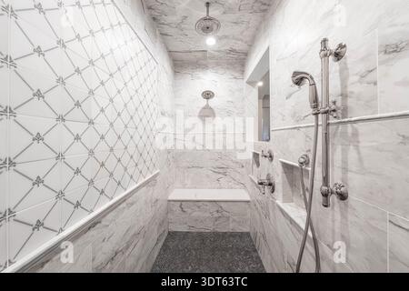 Die Renovierung der begehbaren Dusche ist komplett mit neuen Keramikfliesen und Armaturen Stockfoto