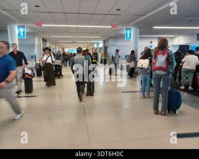 Charlotte, NC, USA - 9. Juni 2025: Menschen laufen an einem geschäftigen Terminal am internationalen Flughafen Charlotte Douglas. Stockfoto