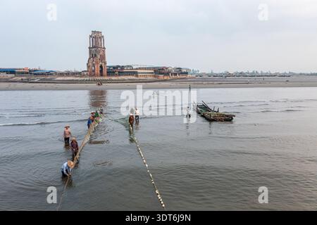 Fischer werfen Netze in flachen Küstengewässern von Hai Hau, Nam Dinh, Vietnam Stockfoto