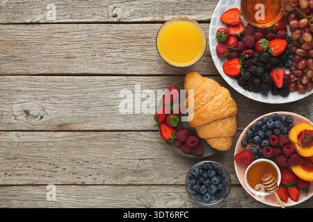 Sammlung von Obst und Gebäck auf Holztisch während des Frühstücks in gemütlicher Umgebung Stockfoto