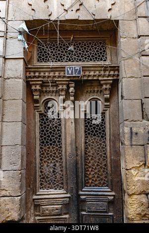 Kairo, Ägypten. 21. Dezember 2022 eine antike Holztür eines Hauses in den engen Gassen des alten Teils des islamischen Kairos Nr Khan el Khalili Basar Stockfoto