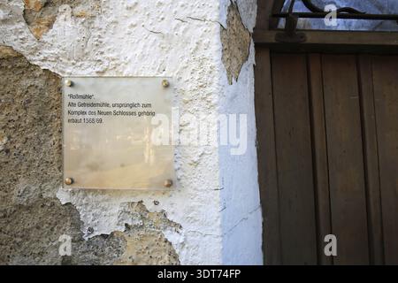 Texttafel an einer verwitterten Steinmauer neben einer Holztür in einem alten Viertel in Ingolstadt, Bayern, Deutschland Stockfoto