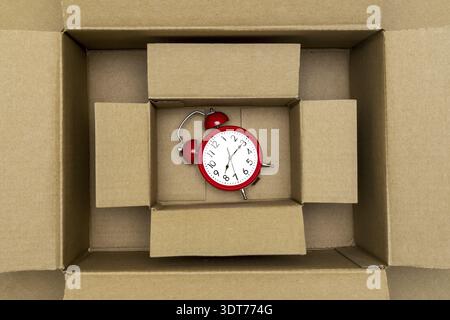 Roter Retro-Wecker im Karton. Draufsicht Stockfoto