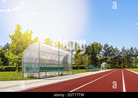 Perspektivische Ansicht eines Freiluftstadions mit roten Laufstrecken, Plastikstühlen, Infrastruktur für sportliche Aktivitäten Stockfoto