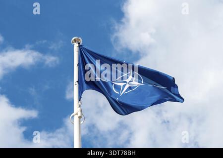 NATO-Flagge im Wind gegen Himmel Hintergrund Stockfoto