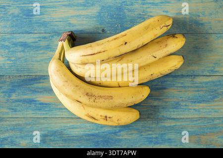 Reihe von großer reife Bananen auf blauen Holzoberfläche Stockfoto