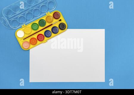 Leeres Stück Papier mit Wasserfarben auf Kinder Schreibtisch, Ansicht von oben mit der Kopie Raum Stockfoto