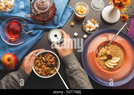 Sammlung von Frühstücksartikeln auf einem Tisch mit Tee und Desserts in gemütlicher Umgebung Stockfoto