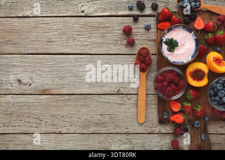 Sammlung von frischem Obst und Joghurt auf Holzoberfläche für gesunde Snackideen Stockfoto