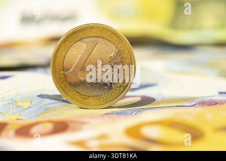 Eine Euro-Münze auf den Banknoten. Nahansicht des Euro-Geldes. Oberer Freiheitsgrad Stockfoto