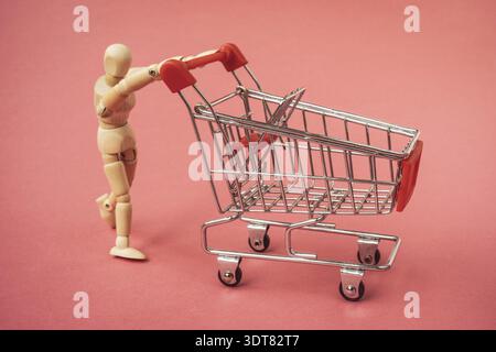 Holzmann schiebt einen leeren Einkaufswagen. Einkaufskonzept Stockfoto
