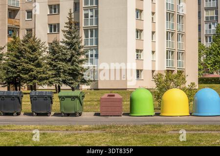 Die verschiedenen Mülltonnen im Wohngebiet. Separates Müllsammelproblem, Recycling von Haushaltsabfällen Stockfoto