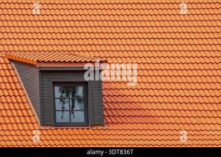 Renoviertes Dachfenster auf dem roten Haus Lehm-Keramik-Fliesen Dach Stockfoto