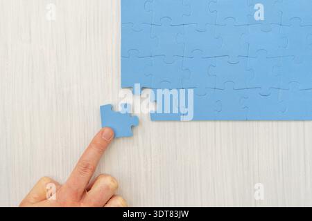 Hand das letzte Puzzleteil. Abschluss der Mission Stockfoto
