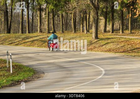 Nicht erkennbare Rückansicht der älteren Mann in einem elektrischen Rollstuhl auf der Straße Stockfoto
