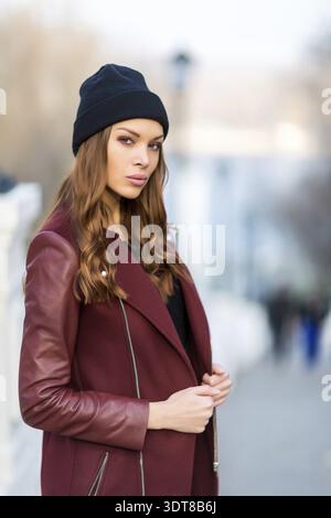 Junge, schöne Frau, die draußen posiert. Stilvolles Modeporträt Stockfoto