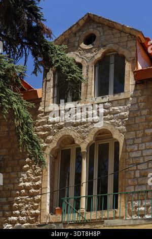 Fassade eines traditionellen libanesischen Hauses mit eleganten Bogenfenstern und klassischer Steinarchitektur. Stockfoto