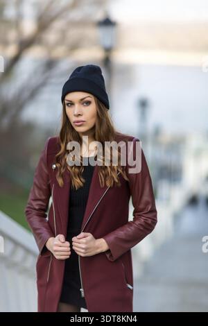 Junge, schöne Frau, die draußen posiert. Stilvolles Modeporträt Stockfoto