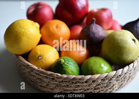 Frische gemischte Früchte in Korb auf weißem Hintergrund, die gesunden Lebensstil und saubere Ernährung repräsentieren Stockfoto