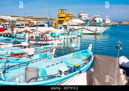 Ayia Napa Hafen auf Zypern, gefüllt mit farbenfrohen traditionellen Fischerbooten. Ruhiges türkisfarbenes Wasser und klarer blauer Himmel schaffen ein malerisches und Stockfoto