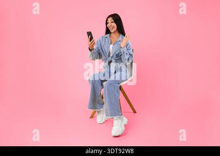 Fröhliche Frau mit Videoanruf mit Handy und winken Stockfoto