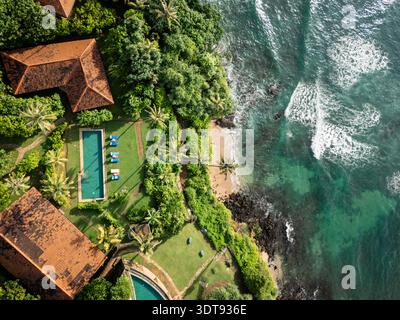 Sri Lanka - 13. Dezember 2024: Luftaufnahme eines luxuriösen tropischen Strandresorts mit Swimmingpool, Villen und Palmen auf Sri Lanka Stockfoto