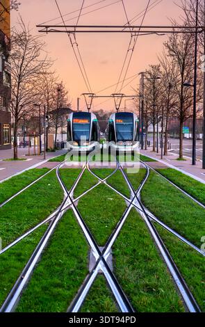 Saint Denis, Frankreich - 29. Dezember 2025: Zwei moderne T8-Straßenbahnen an der Endhaltestelle Saint Denis Porte de Paris an einer grünen Kreuzung. Der Transit verkehrt in der Nähe von Paris. Stockfoto