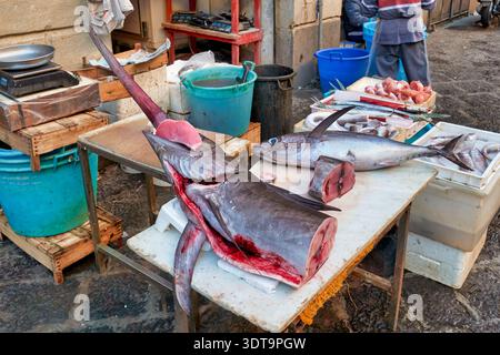 Besucher besuchen den Piscaria Markt in Catania, um frischen Fisch, Fleisch und Gemüse zu kaufen. Die Händler stellen Fisch- und Fleischgerichte auf den Tischen aus. Stockfoto