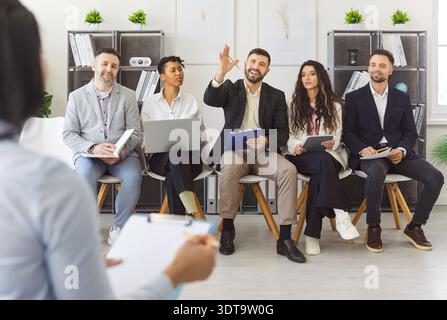 Vielfältige Gruppe von Fachleuten, die im Büro interaktiv diskutieren Stockfoto