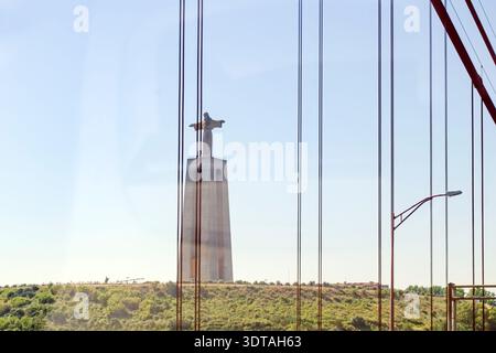 Katholisches Denkmal in Almada, Portugal. Heiligtum Christi des Königs. Im Vordergrund steht die Brücke 25 de Abril. Stockfoto