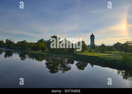 Sonnenaufgang über der Mulde in Eilenburg, Deutschland, mit einem Sonnenhund (Parhelion) und dem historischen Wasserturm in der Ferne Stockfoto