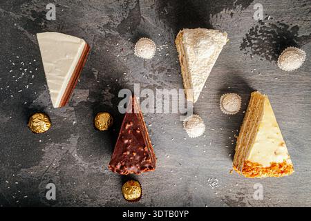 Gemischte Kuchen auf dunklem Steintisch Stockfoto