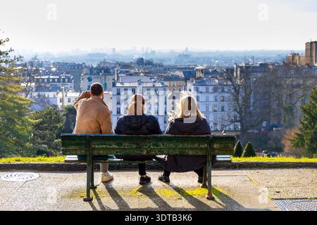 Touristen, die auf der Bank sitzen und einen Blick auf Paris vom Place Louise Michel, Montmartre, Paris, Frankreich haben Stockfoto