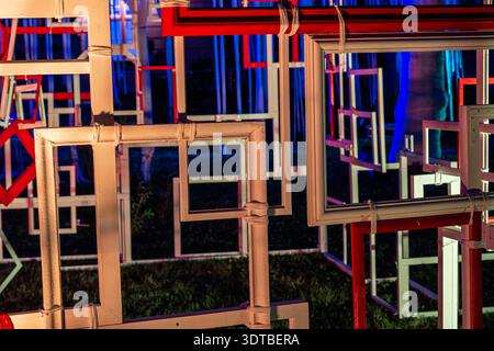 Eine abstrakte Kunstinstallation mit zahlreichen rechteckigen Rahmen unterschiedlicher Größe, gestapelt und überlappend. Die Rahmen werden durch Neonlicht beleuchtet Stockfoto