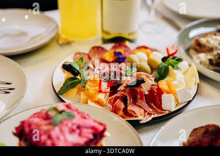 Vorspeisenplatte mit Käse und Fleisch, serviert auf einem eleganten festlichen Restauranttisch Stockfoto