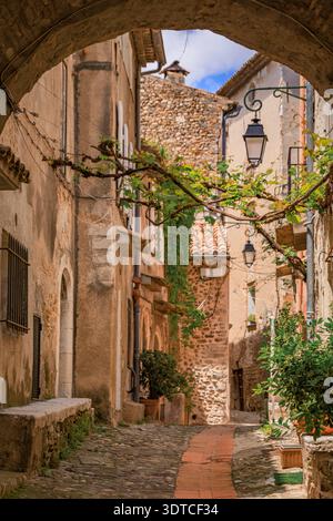 Malerischer Blick durch einen traditionellen gewölbten Steinbogen, farbenfrohe mediterrane Häuser im mittelalterlichen Dorf Haut de Cagnes, Frankreich Stockfoto