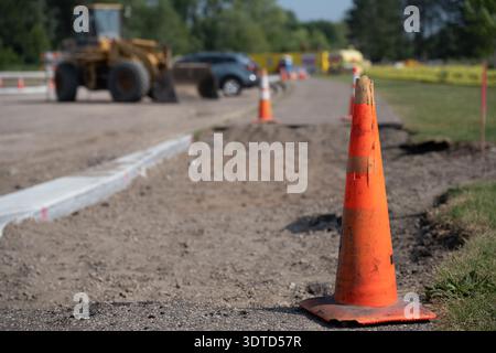 Bauarbeiten auf einer Straße mit Ausrüstung und Kegeln während des Tages an einem sonnigen Tag Stockfoto