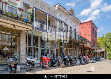 Arkansas, 21. SEP 2024 - Eine Reihe glänzender Motorräder parkt entlang einer charmanten Downtown Street, gesäumt von historischen zweistöckigen Gebäuden mit bal Stockfoto