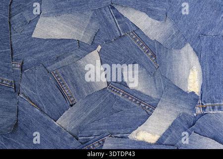Recycling alter Jeans. Denim-Stoff für Hintergrund- und Modetapeten. DIY aus Jeans. Denim Upcycling. Kreislaufwirtschaft. Ein Haufen alter alter blauer jea Stockfoto