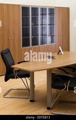 Tisch, Stühle und Bücherregal im modernen Büro Stockfoto