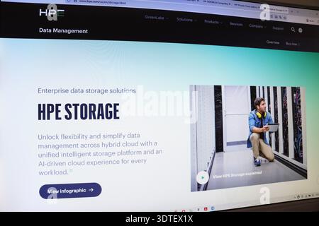 Computerbildschirm, auf dem die Website für Unternehmensdatenspeicherlösungen mit einem Mann im Serverraum mit Tablet angezeigt wird. Informationstechnisches Konzept. Stockfoto