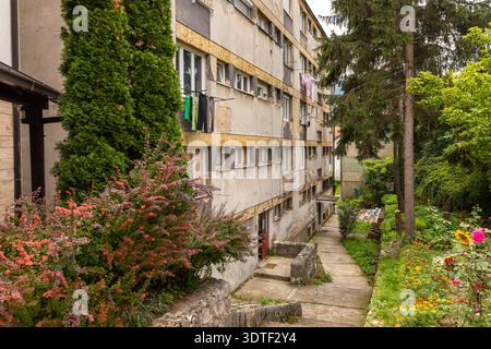 Altes, baufälliges Apartmentgebäude mit trocknender Kleidung auf Balkonen, das urbanen Verfall und Lebensbedingungen in Jajce, Bosnien und Herzegowina, zeigt. Stockfoto