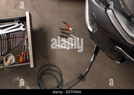 Mechanische Werkzeuge sind in einer Werkstattumgebung organisiert. Links zeigt eine offene Schublade einen Satz Kombinationsschlüssel und Schraubendreher, die gut von arran angebracht sind Stockfoto